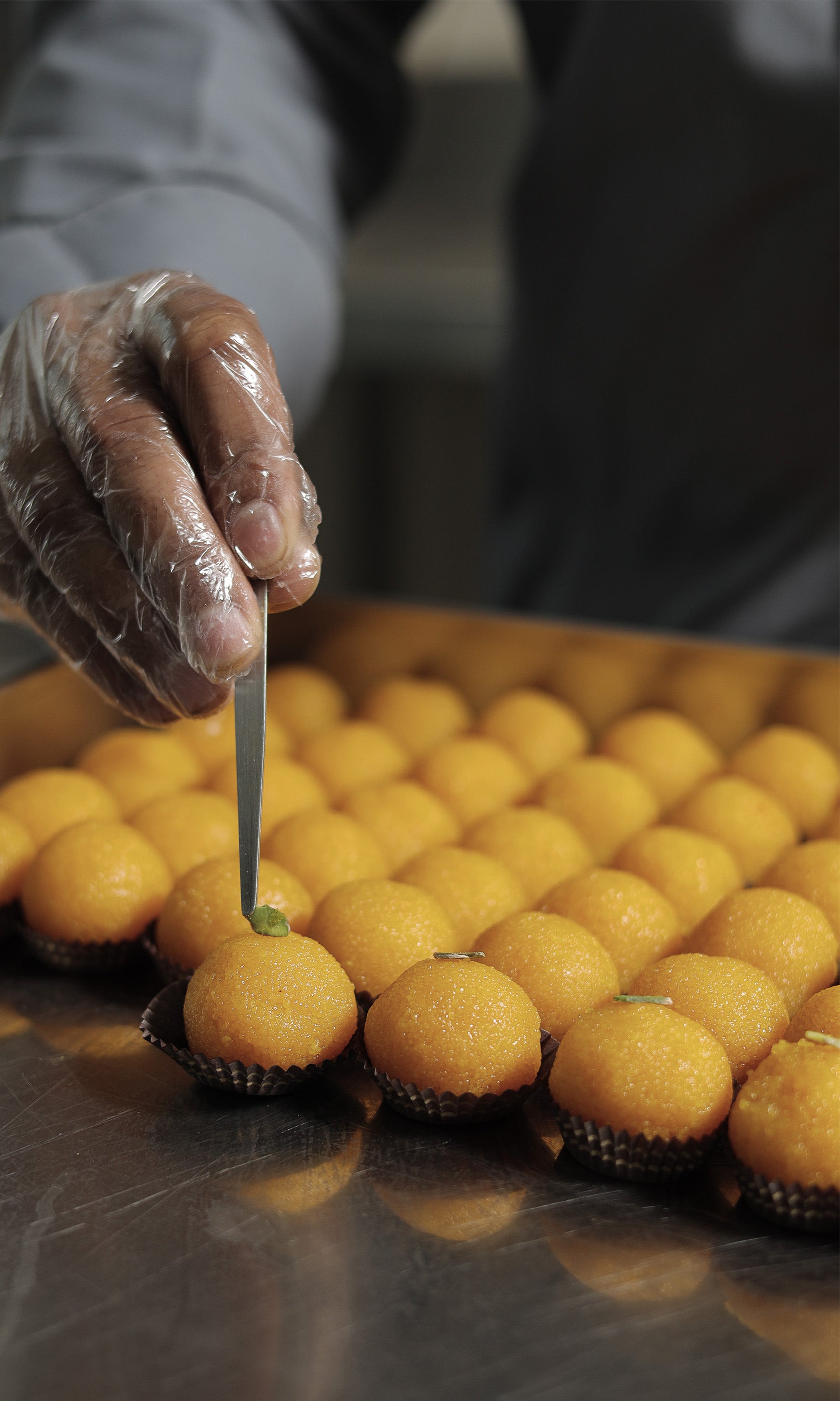 Topping on mithai by hand